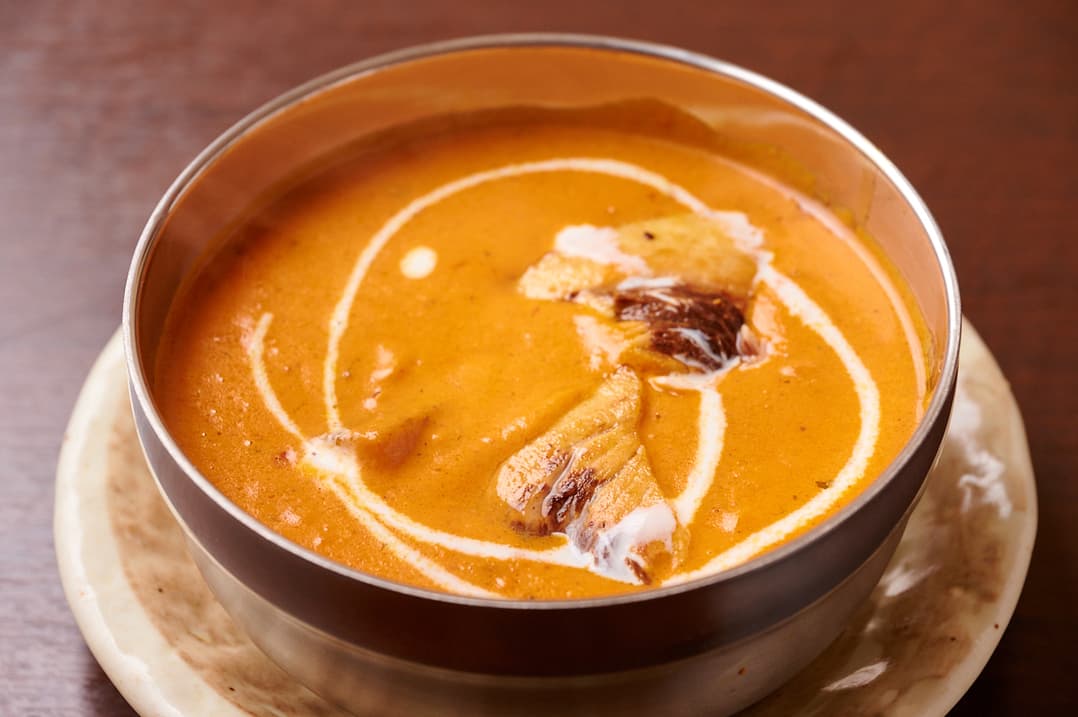 Orange curry garnished with cream at Sakura Asian Dining & Bar