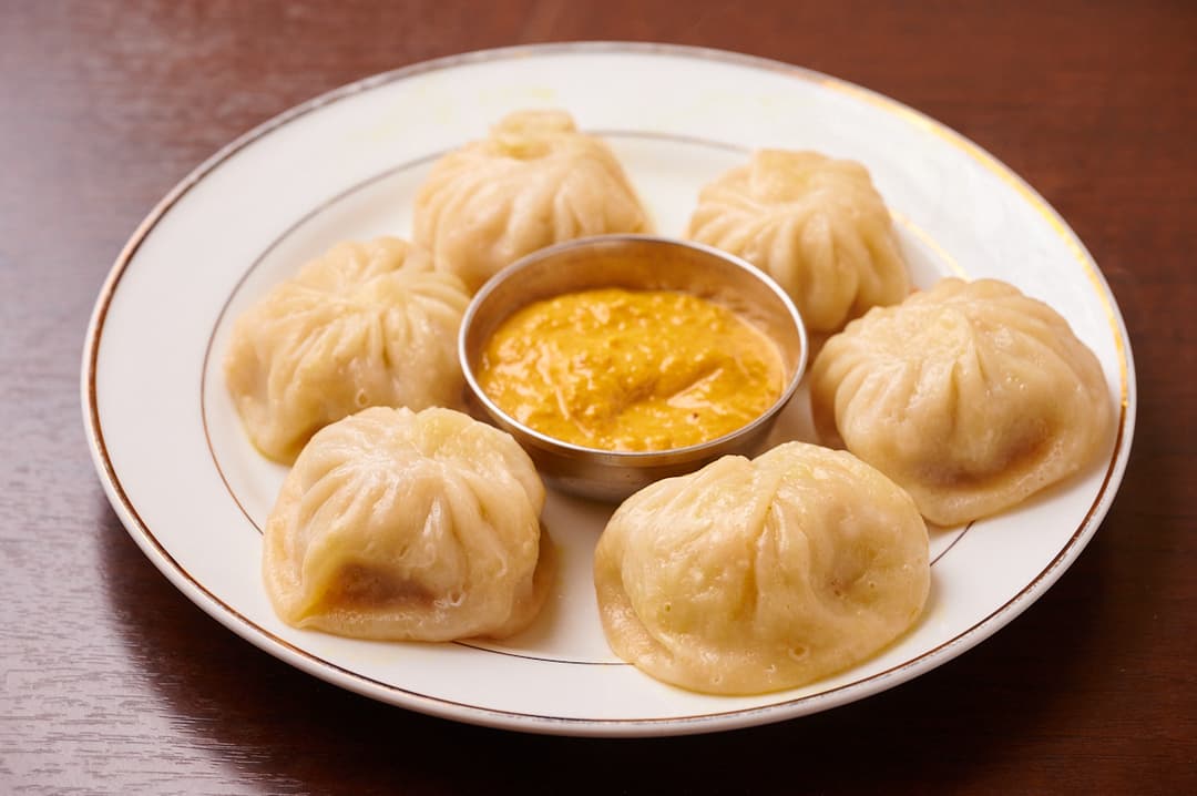 Steamed momo dumplings with dipping sauce at Sakura Asian Dining & Bar